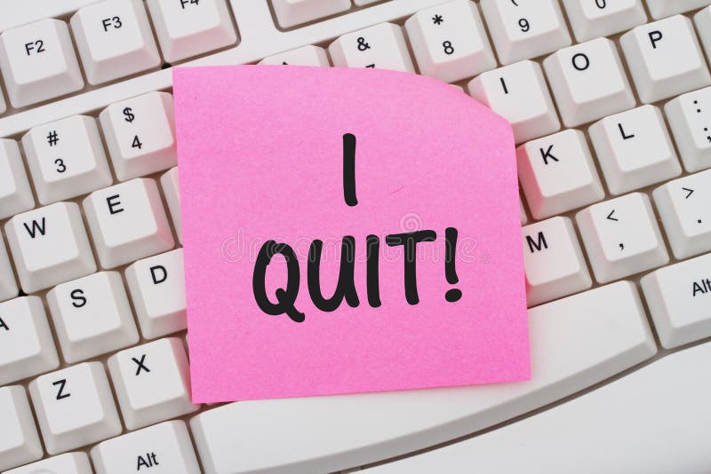 A close-up of a keyboard with pink sticky note with text I Quit. A close-up of a keyboard with pink sticky note with text I Quit