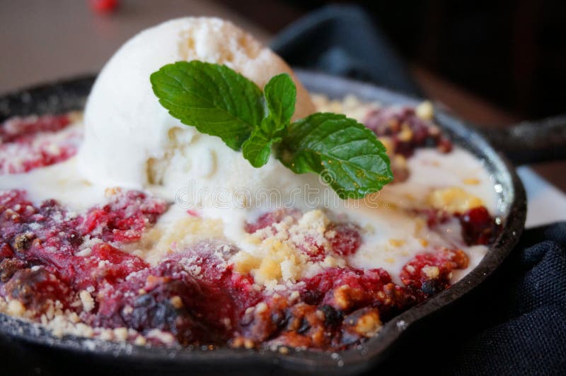 Berry Cobbler in a skillet with ice cream and mint. Berry Cobbler in a skillet with ice cream and mint