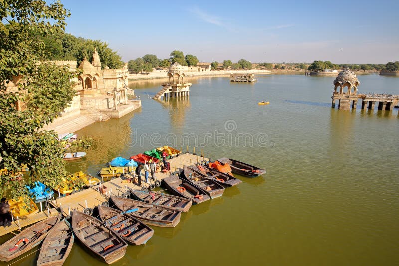 JAISALMER, RAJASTHAN INDIA, GRUDZIEŃ, - 19, 2017: Ogólny widok Gadi Sagar jezioro z paddling łodziami w chhatri i przedpolu fotografia stock JAISALMER, RAJASTHAN INDIA, GRUDZIEŃ, - 19, 2017: Ogólny widok Gadi Sagar jezioro z paddling łodziami w chhatri i przedpolu fotografia stock