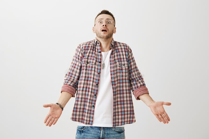 Jak mógł nawet zdarzać się to Studio strzał zmieszany i szokujący młody człowiek z szczecina w modnym eyewear chyleniu fotografia stock Jak mógł nawet zdarzać się to Studio strzał zmieszany i szokujący młody człowiek z szczecina w modnym eyewear chyleniu fotografia stock