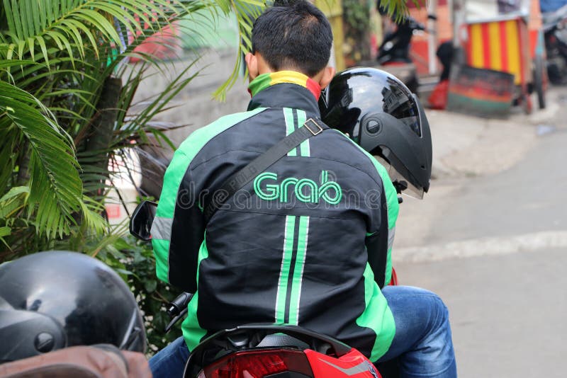 Jakarta, Indonesia May 6, 2019: Behind the man sitting on the motorcycles beside the road who is a Grab bike in Indonesia