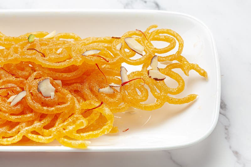 Jalebi classico. smerigliato con zafferano e noci secche jalebi è uno dei dolci più deliziosi. Chiusura di jalebi classico indiano. smerigliato con zafferano di kesar e noci secche jalebi è uno dei dolciumi più deliziosi ampiamente usati per l'attenzione indiaselica sull'argomento