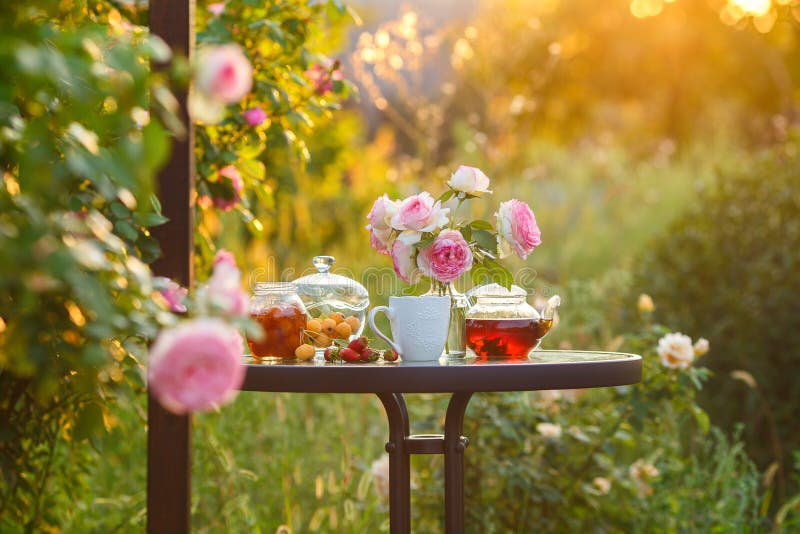 Jam in glass jar. Romantic dinner in the garden under a rose bush. Summer time. Copy space