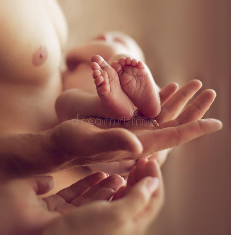 Jambes bébé nouveau-né, qui tiennent son père Le concept du fam photographie stock Jambes bébé nouveau-né, qui tiennent son père Le concept du fam photographie stock