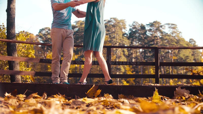 Jambes d'une danse de couples sur le pont en bois