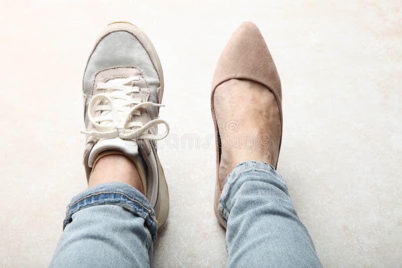 Jambes dans la chaussure de sports et de belles chaussures classiques élégantes images libres de droits Jambes dans la chaussure de sports et de belles chaussures classiques élégantes images libres de droits