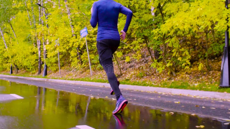 Jambes de jeune homme fonctionnant en parc Automne