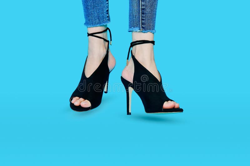 Jambes des femmes utilisant des talons hauts, mode noire admirablement Position sur un fond bleu photos libres de droits