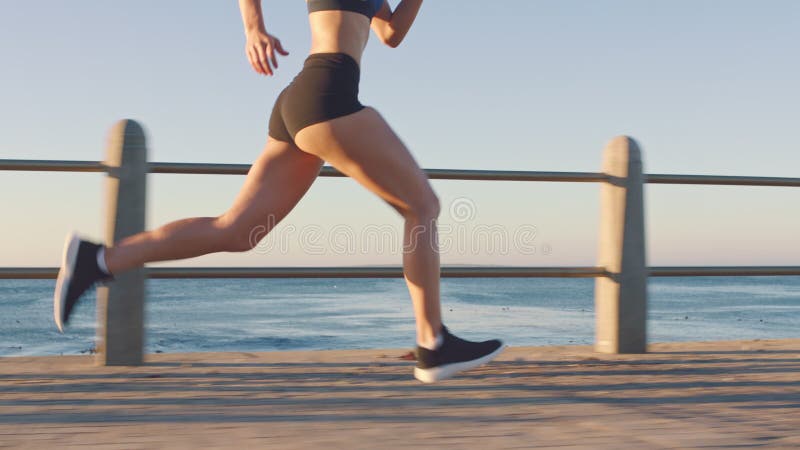 Jambes femme coureur et courir à la plage pour l'exercice cardiovasculaire fitness entraînement et la motivation sportive saine. f banque de vidéos