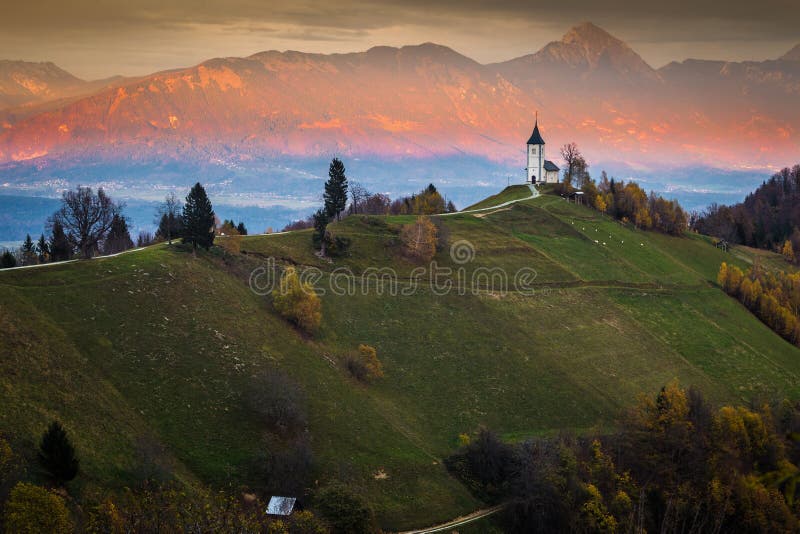 Jamnik, Slovénie - beau coucher du soleil d'or à l'église de St Primoz de Jamnik photos libres de droits Jamnik, Slovénie - beau coucher du soleil d'or à l'église de St Primoz de Jamnik photos libres de droits