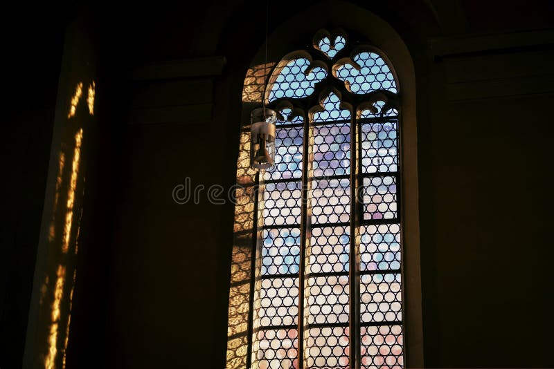 Janela bonita e uma lâmpada na igreja Católica alemão Luz e sombra imagens de stock Janela bonita e uma lâmpada na igreja Católica alemão Luz e sombra imagens de stock