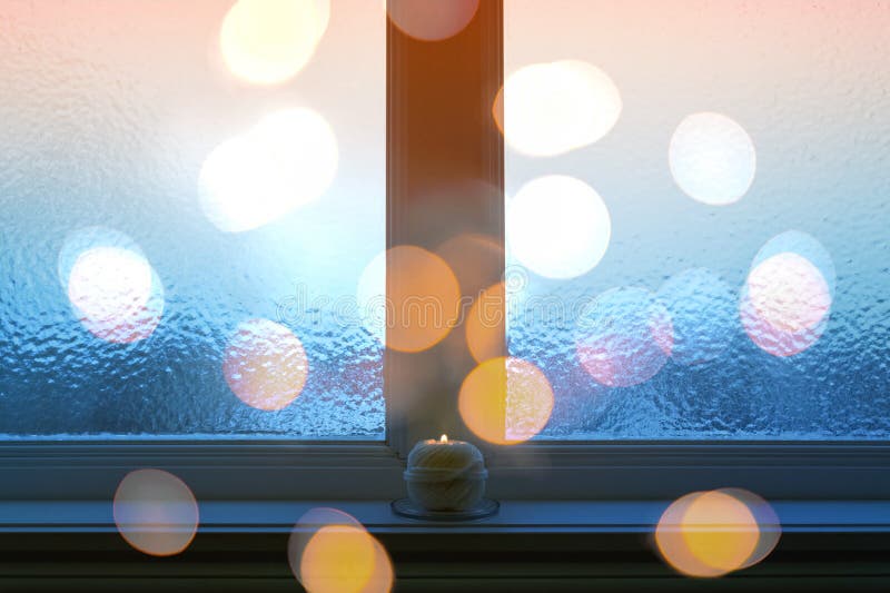 Janela geada, luzes do bokeh, e vela de queimadura fotos de stock royalty free Janela geada, luzes do bokeh, e vela de queimadura fotos de stock royalty free