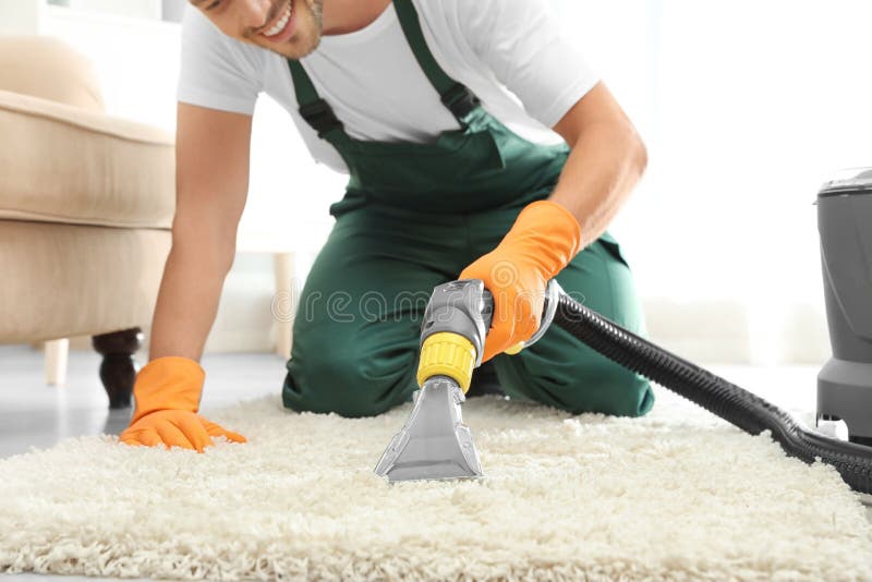 Janitor removing dirt from rug with carpet cleaner indoor stock photos Janitor removing dirt from rug with carpet cleaner indoor stock photos
