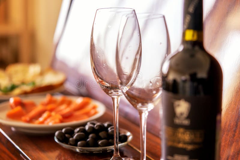 Jantar e vinho tinto românticos os pratos estão no piano: peixes, azeitonas, vidros foto de stock Jantar e vinho tinto românticos os pratos estão no piano: peixes, azeitonas, vidros foto de stock