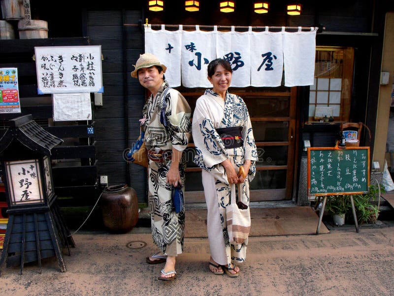 A Japanese couple pose dressed in the traditional kimono at the door of a restaurant in Tokyo stock image