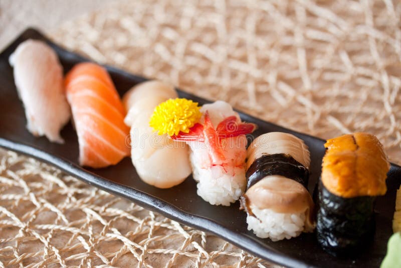 Un simpatico set di presentazione di sushi, piatto di salmone, coda gialla, pesce spada, dolce, gamberi, ricci di mare, abalone e hokkaido pettine sushi.