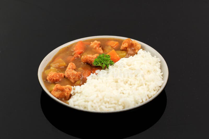 Japanese or Korean Curry with Rice - Japanese Food Style. Served on Ceramic Plate Isolated on Black with Potato , Crispy Chicken