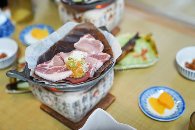 Japanese pork grill style on the traditional stove with local dry leaf and appetizer around royalty free stock photography Japanese pork grill style on the traditional stove with local dry leaf and appetizer around royalty free stock photography