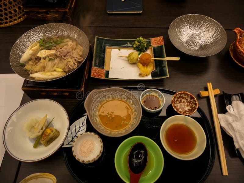 Japanese ryokan kaiseki dinner sets serve in family private room including  appetizer such as cherry blossom tofu, pork shabu hot pot and basket,  sashimi, fried and warm dishes and plum liquor Stock