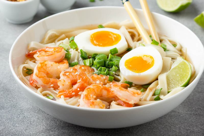 Japanese soup with wheat noodles, fried shrimp, soft-boiled egg with liquid yolk and green onions. Traditional Asian ramen