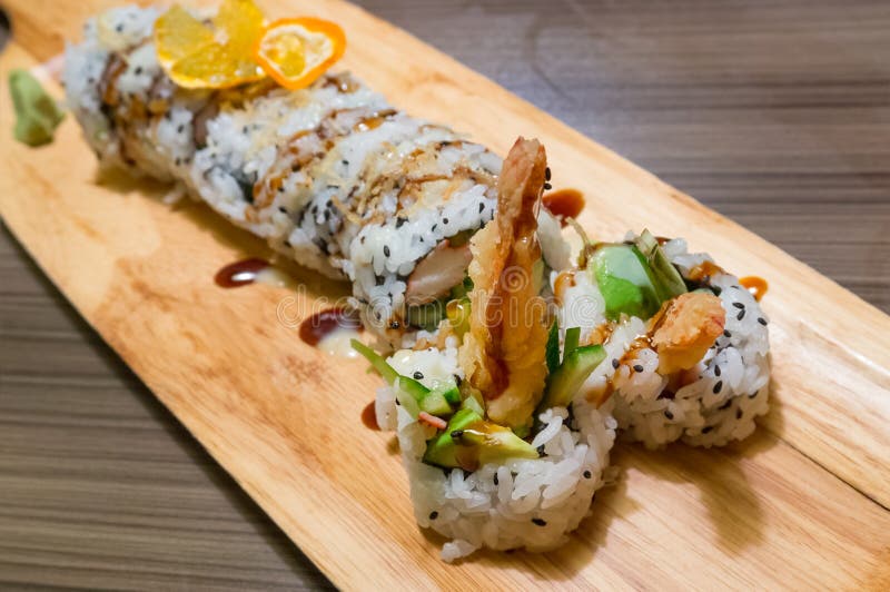 Giapponese panini profondo fritto gamberetti,, cetriolo, alghe marine un spruzzato nero sesamo, ridurre su sul legna piatto un piccolo quantità da salsa sul.