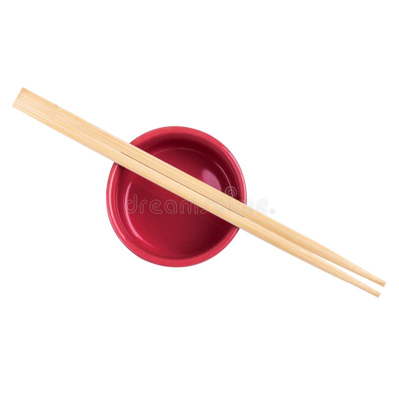 Japanese sushi sticks or chopsticks over red sauce bowl isolated on white background. Top view royalty free stock image Japanese sushi sticks or chopsticks over red sauce bowl isolated on white background. Top view royalty free stock image