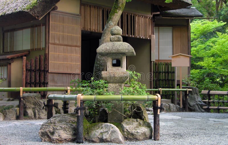 Very traditional Japanese tea house with stone lantern in front of it. Location:Golden Temple garden, Kyoto, Japan