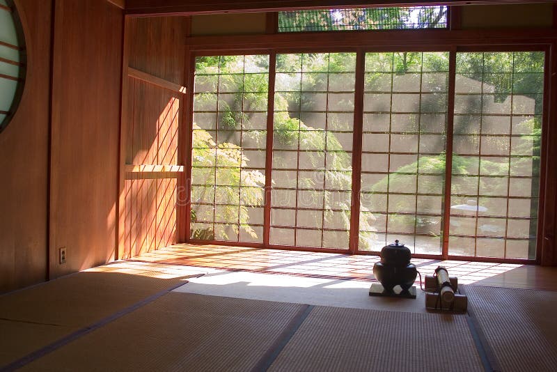 An interior view of a Japanese Tea House looking out through the screen doors on a sunny day.