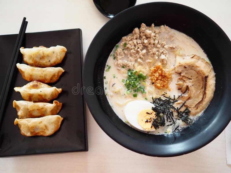 Tonkotsu ramen topping with Chaashu , Nori , Negi, tamago eat with Gyoza and ice cold green tea