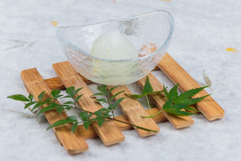 Japanese Yuzu Sorbet served one scoop on glass bowl on wooden saucer on washi Japanese paper