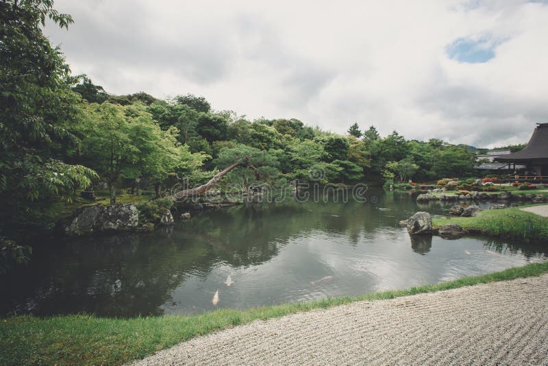 Japanese zen stone garden and lake with green maple leaves film vintage style stock image Japanese zen stone garden and lake with green maple leaves film vintage style stock image
