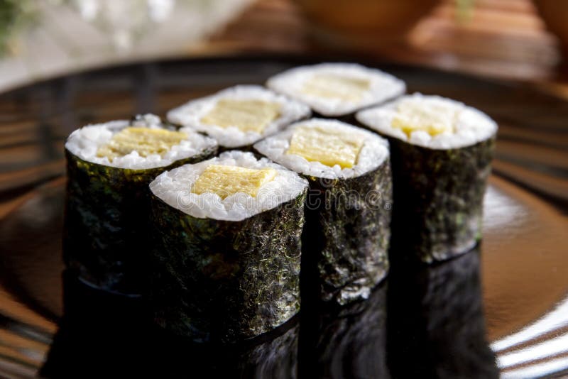 Japanische Lebensmittel tamago maki Sushi auf Schwarzblech stockfoto Japanische Lebensmittel tamago maki Sushi auf Schwarzblech stockfoto