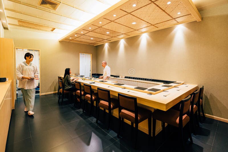 Japansk Omakase restaurang som dekorerade mestadels med trä Kock som lagar mat i diskbänk arkivbild Japansk Omakase restaurang som dekorerade mestadels med trä Kock som lagar mat i diskbänk arkivbild