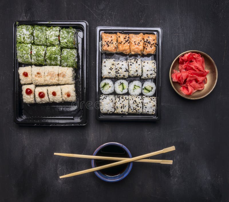 Japansk snabbmat, sushiuppsättning med olika ingredienser i plast- behållare på mörk lantlig bakgrund, bästa sikt arkivbild Japansk snabbmat, sushiuppsättning med olika ingredienser i plast- behållare på mörk lantlig bakgrund, bästa sikt arkivbild