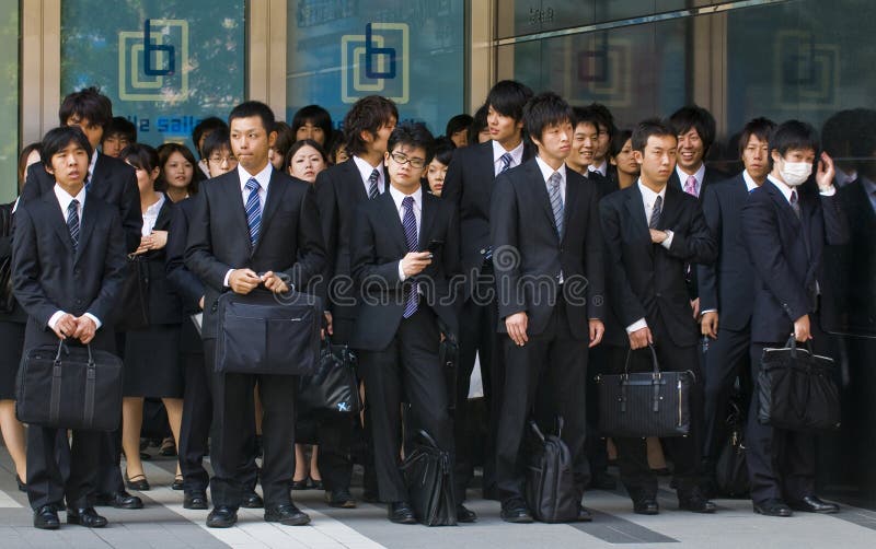 TOKYO - OCT 29 : Japanese office workers stands outside an office building in Tokyo Japan financial district on October 29 2009. TOKYO - OCT 29 : Japanese office workers stands outside an office building in Tokyo Japan financial district on October 29 2009