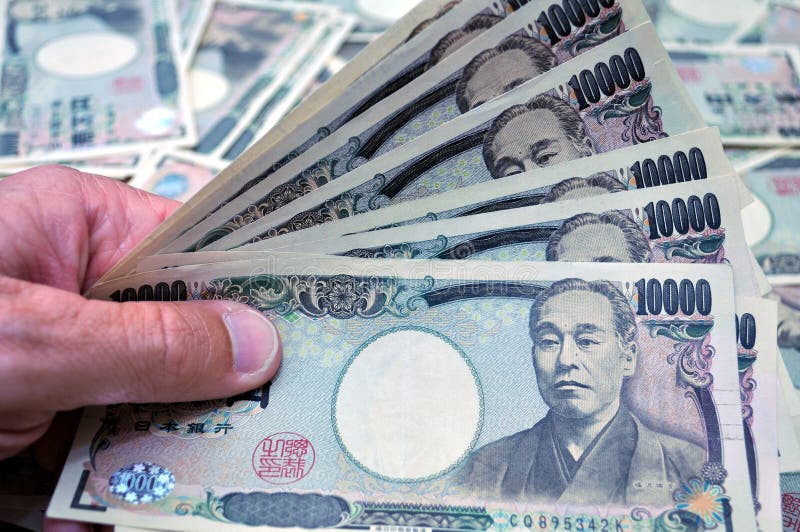 An closeup picture of a hand holding Japanese 10000 yen notes. An closeup picture of a hand holding Japanese 10000 yen notes