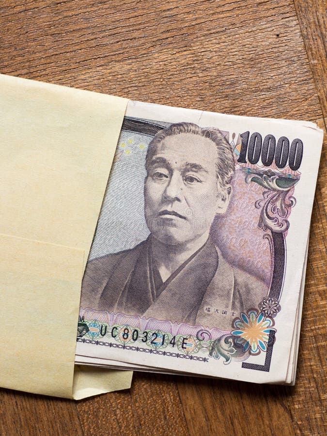 Japanese 10000 yen bill in the envelope on the wooden table. Japanese 10000 yen bill in the envelope on the wooden table