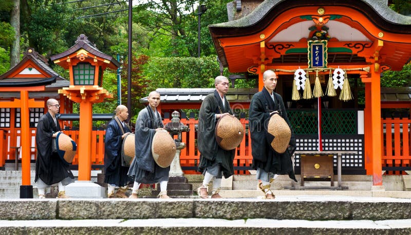 Kyoto, Japan - July 7, 2012 - Japanese monks walk through Fushimi-Inari, a shinto shrine in Kyoto. In 2011, the shrine celebrated its 1300th birthday. In the first three days of each new year, over 3 million people flock to Fushimi-Inari for their first shrine visit of the year. Kyoto, Japan - July 7, 2012 - Japanese monks walk through Fushimi-Inari, a shinto shrine in Kyoto. In 2011, the shrine celebrated its 1300th birthday. In the first three days of each new year, over 3 million people flock to Fushimi-Inari for their first shrine visit of the year.