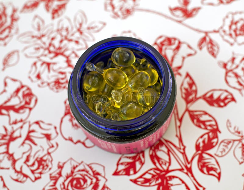 Jar with ampoules with oil - a cosmetic product on a floral background