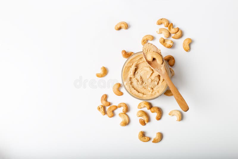 Jar of cashew butter with cashew nuts on the white  background