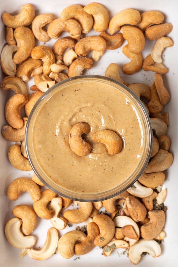 Jar of cashew butter with cashew nuts on the white  background. Top view.