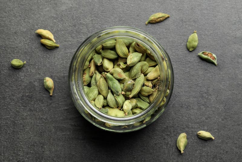 Jar with Dry Cardamom Pods on Dark Grey Table, Top View Stock Photo
