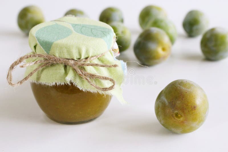Jar of greengage jam on white wooden background . Delicious fruit . Blurred background.Food and healthy concept.