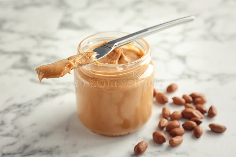 Jar and knife with creamy peanut butter on white background Stock Photo by  ©NewAfrica 193150800