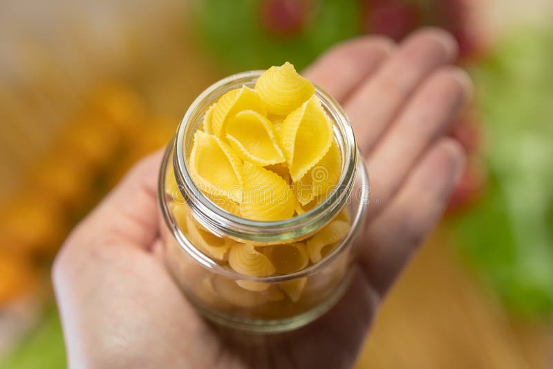 Jar of Pasta in Hand. Cooking. Pasta Recipe from Tomatoes and Herbs