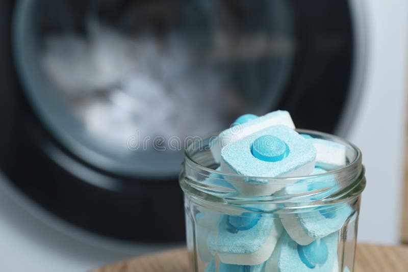 Jar with Water Softener Tablets Near Washing Machine, Closeup. Space