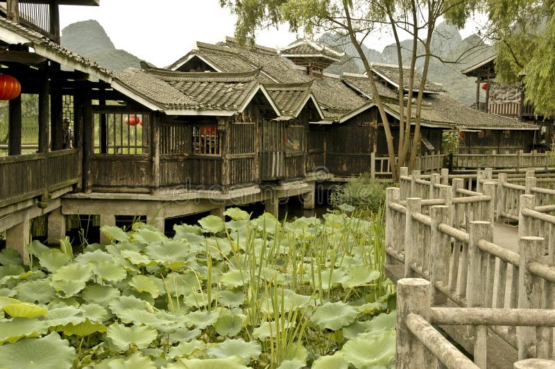 A tranquil floating garden in Southern China with a rambling house and pathway. A tranquil floating garden in Southern China with a rambling house and pathway.