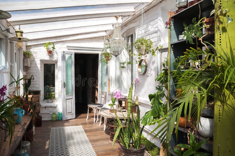 Jardin d'hiver avec un bon nombre d'usines L'espace dans la maison pour la relaxation avec des fleurs Jardinage, véranda dans rus image stock Jardin d'hiver avec un bon nombre d'usines L'espace dans la maison pour la relaxation avec des fleurs Jardinage, véranda dans rus image stock