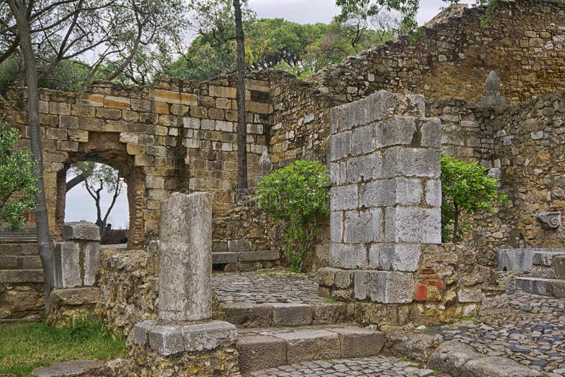 Saint George Castle is a Moorish castle occupying a commanding hilltop overlooking the historic centre of the Portuguese city of Lisbon and Tagus River. The strongly fortified citadel dates from medieval period of Portuguese history, and is one of the main tourist sites of Lisbon. Although the first fortifications on this hilltop date from the 2nd century BC, archaeological excavations have identified a human presence in the Tagus valley as far back as the 6th century BC. The first fortification was, presumably, erected in 48 BC, when Lisbon was classified as a Roman municipality. The hill was first used by indigenous Celtic tribes, then by Phoenicians, Greeks, and Carthaginians as a defensible outpost that was later expropriated by Roman, Suebic, Visigothic, and Moorish peoples. During the 10th century, the fortifications were rebuilt by Muslim Berber forces, these included the walls or Cerca Moura `Moorish Encirclement`. Saint George Castle is a Moorish castle occupying a commanding hilltop overlooking the historic centre of the Portuguese city of Lisbon and Tagus River. The strongly fortified citadel dates from medieval period of Portuguese history, and is one of the main tourist sites of Lisbon. Although the first fortifications on this hilltop date from the 2nd century BC, archaeological excavations have identified a human presence in the Tagus valley as far back as the 6th century BC. The first fortification was, presumably, erected in 48 BC, when Lisbon was classified as a Roman municipality. The hill was first used by indigenous Celtic tribes, then by Phoenicians, Greeks, and Carthaginians as a defensible outpost that was later expropriated by Roman, Suebic, Visigothic, and Moorish peoples. During the 10th century, the fortifications were rebuilt by Muslim Berber forces, these included the walls or Cerca Moura `Moorish Encirclement`.