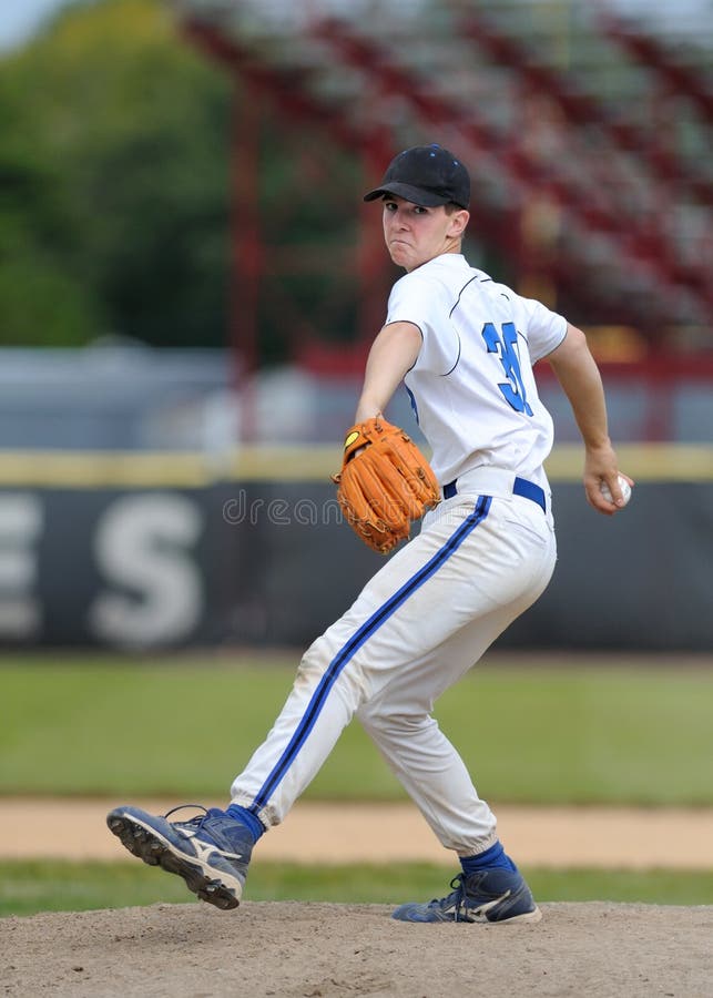 Caucasian high school baseball pitcher delivering pitch to home plate. Caucasian high school baseball pitcher delivering pitch to home plate